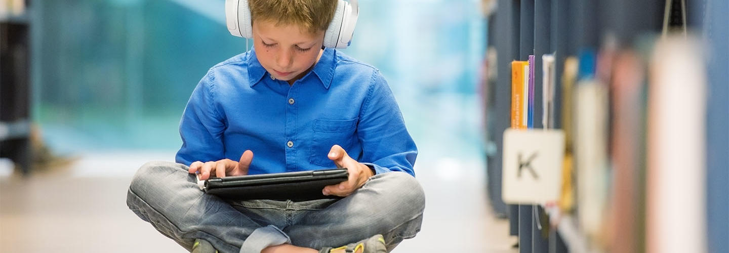 Child on tablet in a library